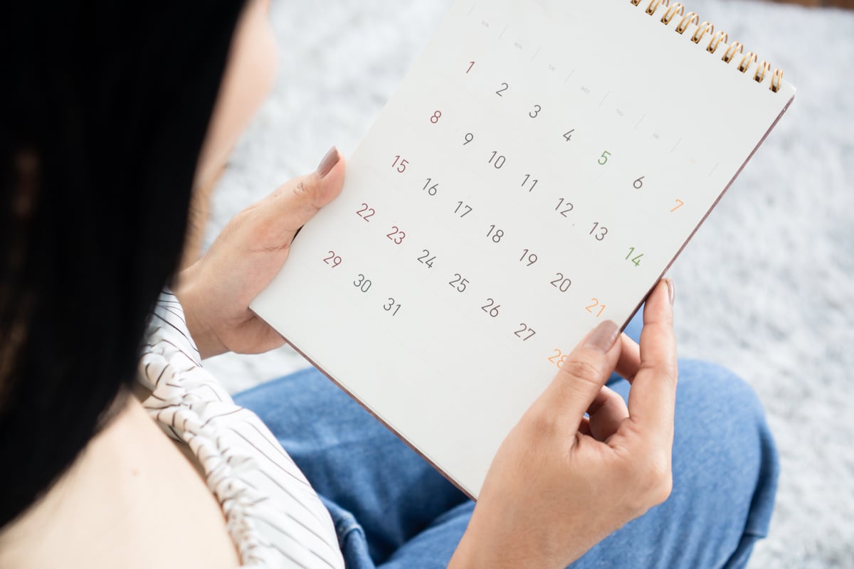 Menstrual Cycle concept ,woman hand Using a calendar for ovulation and period planning